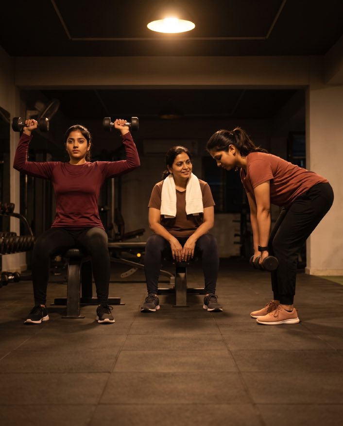 Three women training together in the gym aisle